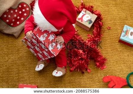 Picture of a happy baby playing with christmas gift box