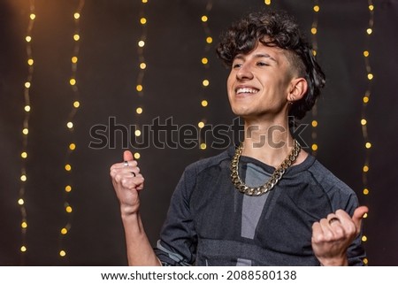 A happy caucasian young man dancing with clenched fists