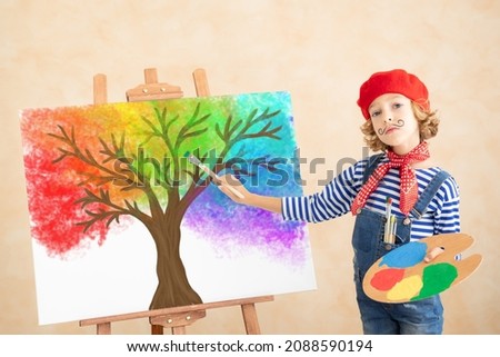 Child painting the rainbow leaver on canvas. Funny girl pretend to be painter. Imagination and childhood dream concept