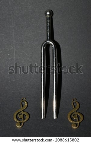 Vaduz, Liechtenstein, November 19, 2021 Tuning fork with two clefs on a black background