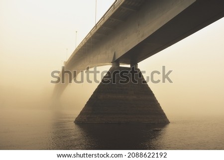 bridge in dense fog at dawn, pedestrian bridge over the Volkhov river in Veliky Novgorod Royalty-Free Stock Photo #2088622192