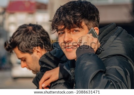 young boys with phones on the street
