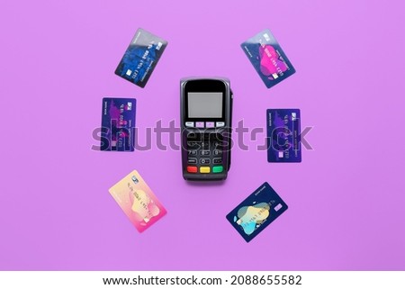 Payment terminal with credit cards on color background