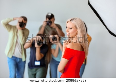 Young photographers taking picture of woman in studio