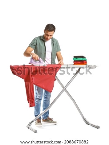 Handsome young man ironing clothes on white background