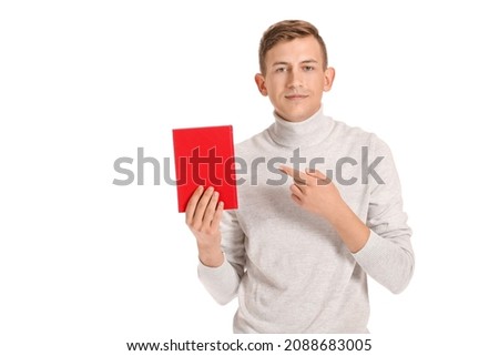 Young man with red book on white background