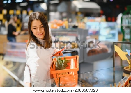 Woman grocery shopping and looking very happy