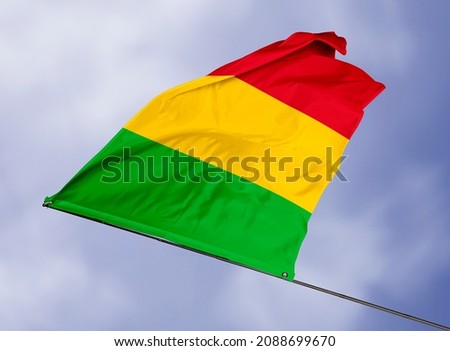 Mali's flag is isolated on a sky background. flag symbols of Mali. close up of a Malian flag waving in the wind.