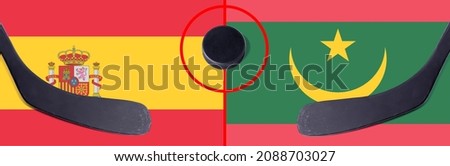 Top view hockey puck with Spain vs. Mauritania command with the sticks on the flag. Concept hockey competitions