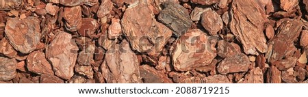 Abstract wooden, chaotic texture and background. Mosaic pattern of an innovative type of floor. Pine bark or mulch carpet. Timber product for the garden covering, relaxing or children zone. Panorama Royalty-Free Stock Photo #2088719215