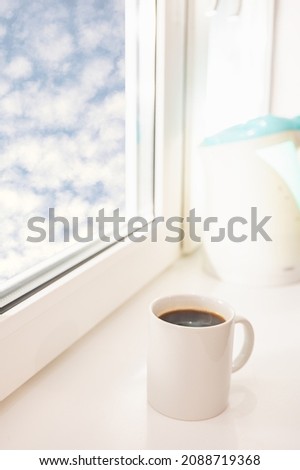 white porcelain coffee cup on the windowsill summer morning