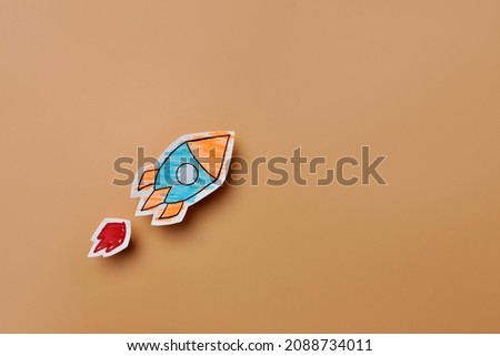 Paper rocket on beige background. A symbol of development and a quick start in business