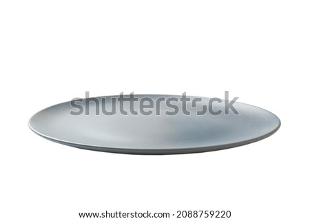 Blue ceramic round plate isolated over white background. perspective view.
