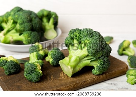 fresh green broccoli on wooden cutting board with knife. Broccoli cabbage leaves. light background. Flat lay. Royalty-Free Stock Photo #2088759238