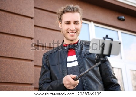 Handsome young man taking selfie outdoors