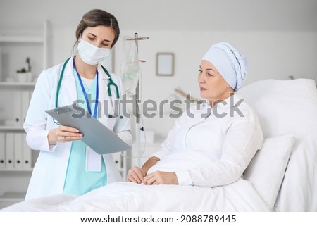 Doctor telling news to mature woman after chemotherapy in clinic Royalty-Free Stock Photo #2088789445