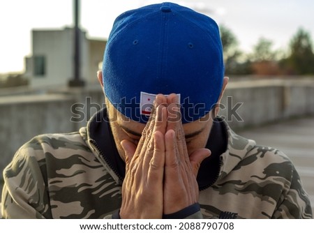 Portrait of a man with his head facing down and his hands in a prayer position. Royalty-Free Stock Photo #2088790708