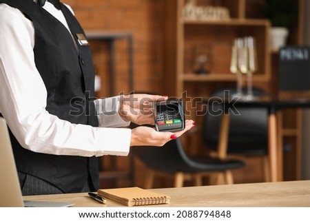 Waiter with payment terminal in cafe