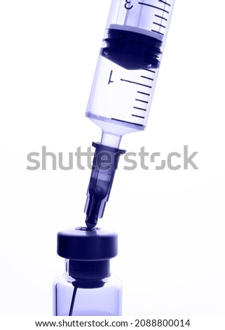 Glass medical ampoule for vaccination and disposable plastic syringe. 2022 very peri color. Royalty-Free Stock Photo #2088800014