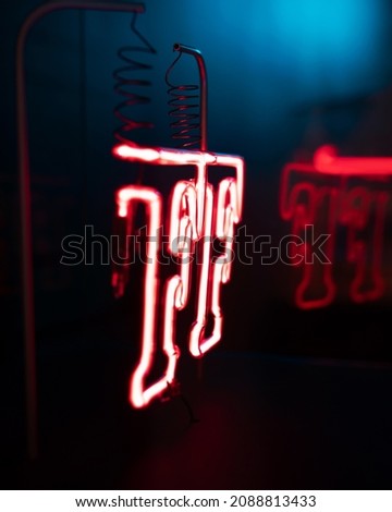 Vertical Shot of a Red Neon Sign on a Black Background.