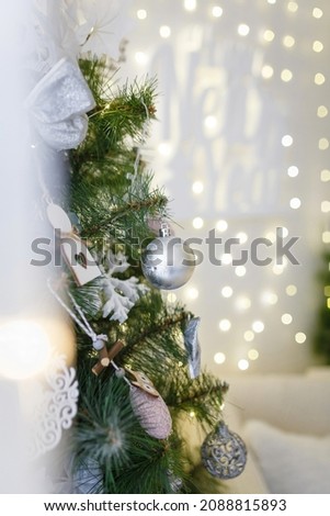 Beautigul decorated fir tree branches with baubles and garlands lights boke on background. Merry Christmas vibes. Vertical shot