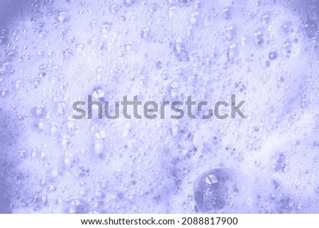 Abstract texture of soap foam and bubbles for background and space for text toned in trendy Very Peri. Color of 2022.