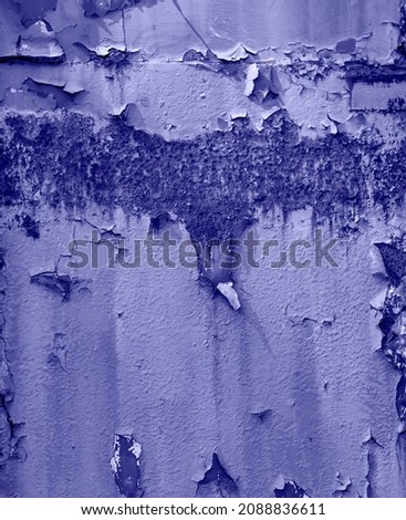Dark rusty metal surface with corrosion and cracked blue Very Peri color paint texture background