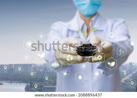 Doctor showing a medical sample of a sprout against the backdrop of a city skyline.