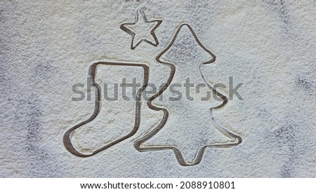 Christmas cookie cutter, pine tree, boot and star, in flour. Modeling cookies for Christmas. Space for text.