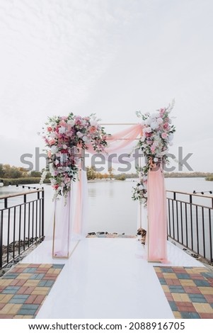Fall wedding with pink roaming ceremony by the water on the pier