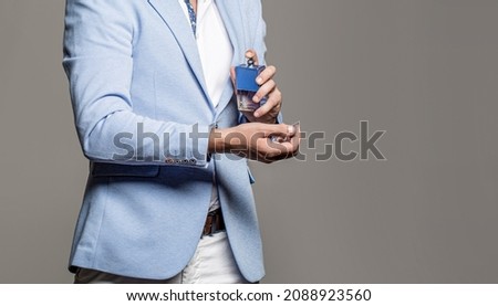 Masculine perfume, bearded man in a suit. Male holding up bottle of perfume. Man perfume, fragrance. Royalty-Free Stock Photo #2088923560
