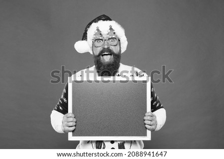 Winter price drop. Bearded hipster Santa claus. Joyful man show blackboard copy space. Happy winter holidays. Presentation or announcement. Promoting winter goods and services. Ski rental concept