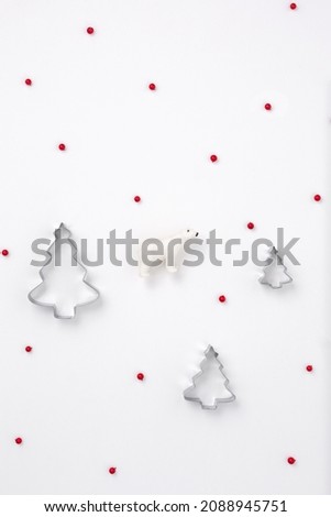 Minimal New Year composition polar bear among Christmas trees and red winter berries. New year concept. Gift wrapping pattern 