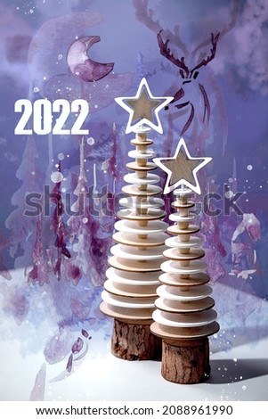 New year 2022 design greeting card with modern Christmas decoration wooden fir trees and watercolor creative elements over Very Peri color of the year.