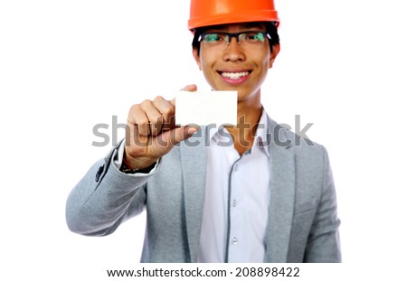 Young asian man with safety helmet holding blank card. Focus on card