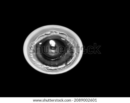 Abstract black and white image of candles in ice dish. as it melts the ice it dissolves itself and finally into darkness 