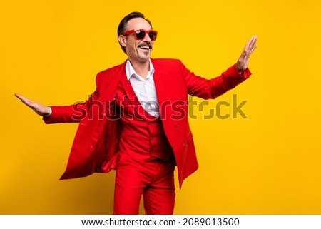 Photo of good mood funky middle age male dancing in red tuxedo sunglass feeling young isolated on yellow color background