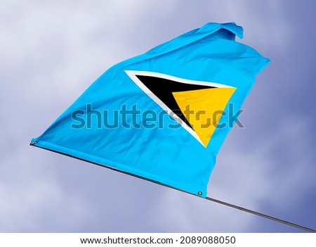 Saint Lucia's flag is isolated on a sky background. flag symbols of Saint Lucia. close up of a Saint Lucian flag waving in the wind.