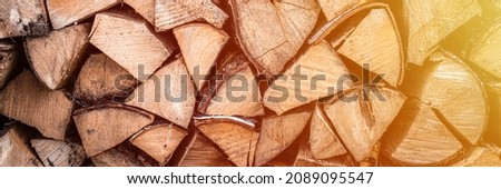 textured firewood background of chopped wood for kindling and heating the house. a woodpile with stacked firewood. the texture of the birch tree. banner. flare