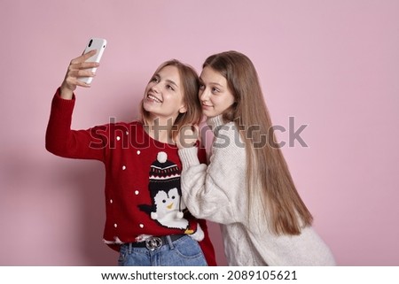 two cute girls in new year sweaters take a selfie