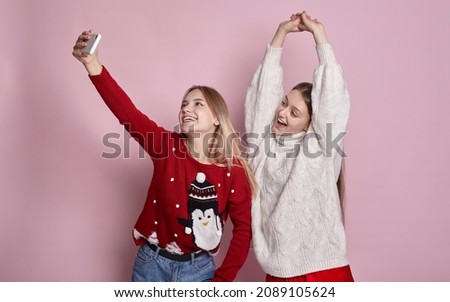 two cute girls in new year sweaters take a selfie