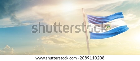 Nicaragua national flag waving in beautiful sky.