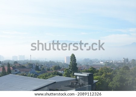 Top view of city buildings and panoramic view of nature on rooftop towards city center. Top view of Bandung tourist center.