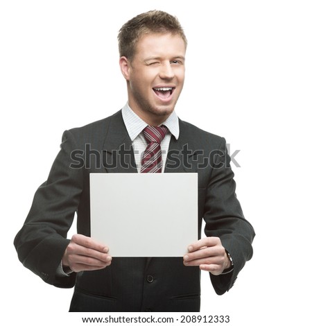 young winking caucasian businessman in black suit holding sign isolated on white