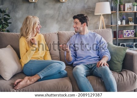 Photo of pretty cute young couple wear casual outfits smiling sitting couch communicating indoors house room Royalty-Free Stock Photo #2089129387
