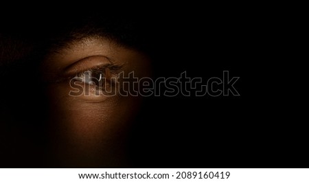 eyes hidden in darkness  . spying concept Royalty-Free Stock Photo #2089160419