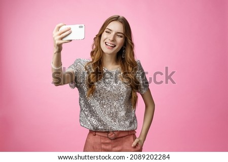 Sociable good-looking confident feminine caucasian woman recording video message taking selfie holding smartphone upper angle capturing image partying send photo online, posing pink background