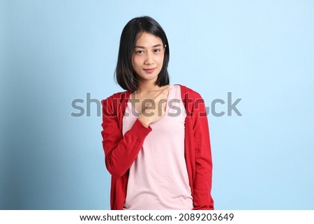 The beautiful Asian woman standing on the blue background.