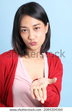 The portrait of Asian woman on the blue background.