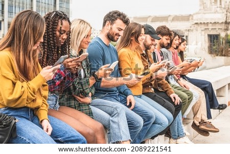 large group of people sitting outdoor and looking at smart phones, social network and media addicted young person concept Royalty-Free Stock Photo #2089221541